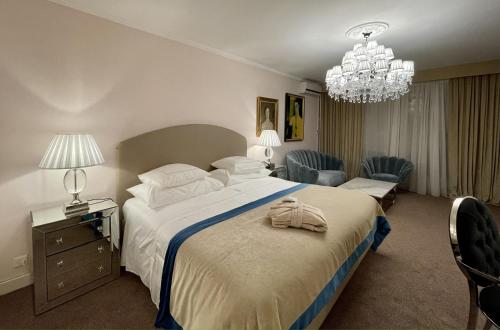 a bedroom with a large bed and a chandelier at Hotel Adriatica in Geneva