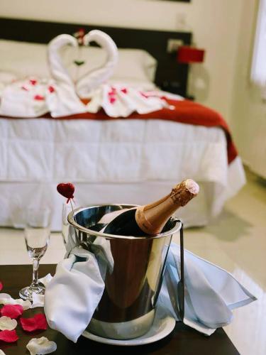 a table with a bucket of wine and a bed at Hotel Dalai in Mendoza