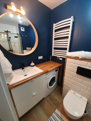a bathroom with a sink and a toilet and a mirror at LEOmare in Międzywodzie