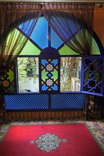 a room with a stained glass window with a red carpet at Riad Maryam Taroudant in Taroudant