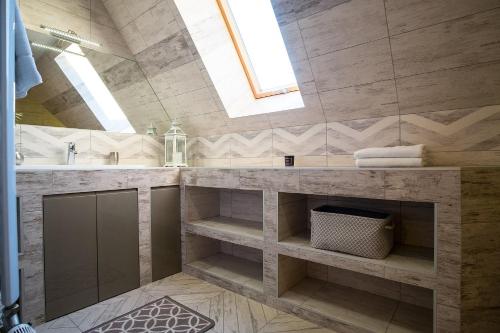 a bathroom with a sink and a shower with a skylight at Apartamenty Magiczny Kącik in Poronin