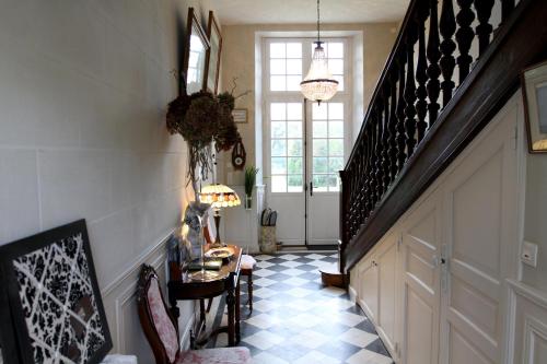 a hallway with a staircase and a table in a room at Château du Bois de La Noe in Bouaye