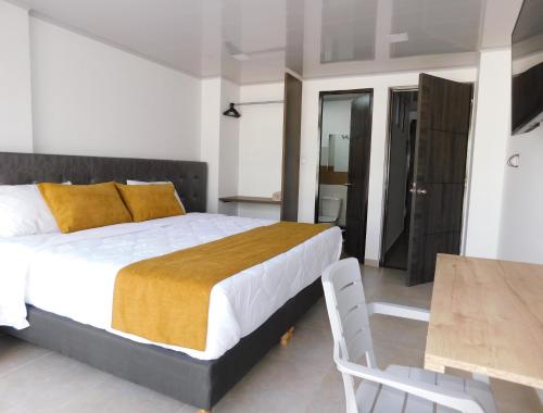 a bedroom with a large bed and a table and chairs at Hotel Monarka-Edificio in Popayan