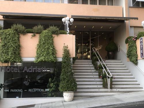 a building with stairs and plants in front of it at Hotel Adriatica in Geneva