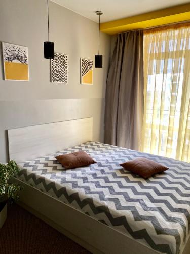 a bedroom with a bed with two pillows on it at Belvederska apartment 2 in Ivano-Frankivsk