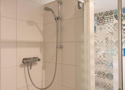 a shower with a glass door in a bathroom at Vakantiehuis Duinwald, geschikt voor 8 personen in Bergen