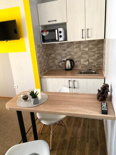 a small kitchen with a wooden table and a sink at Belvederska apartment 2 in Ivano-Frankivsk