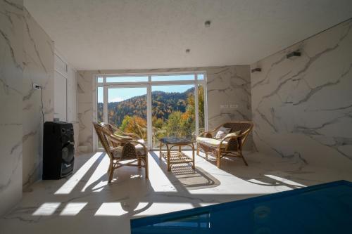 a room with two chairs and a table and a window at Villa Sarajevo in Vareš