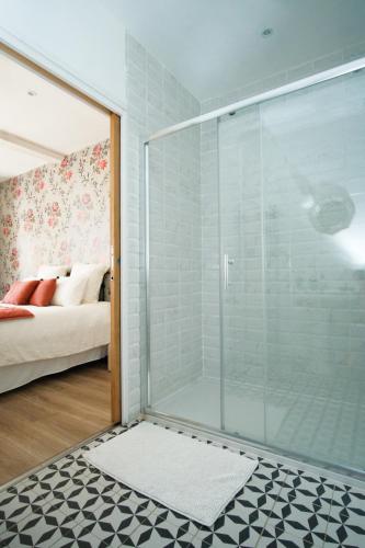 a glass shower in a room with a bedroom at Le Domaine de l'Hostellerie in Le Fresne-Camilly