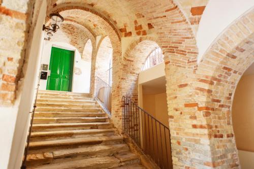 a staircase in an old building with a green door at Residenza Sveva in Termoli