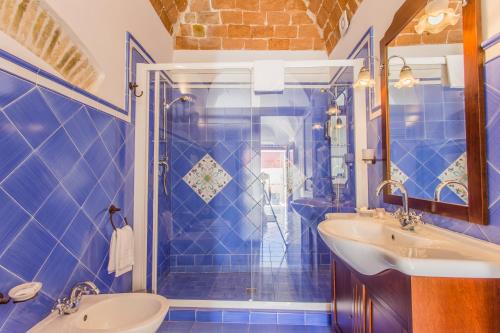 a blue tiled bathroom with a sink and a shower at Residenza Sveva in Termoli