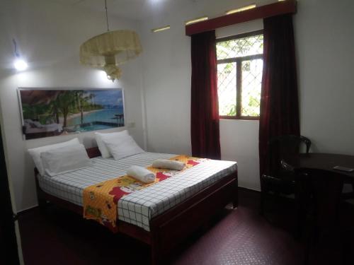 1 dormitorio con 1 cama con 2 toallas en Erandi Holiday Home, en Andiambalama