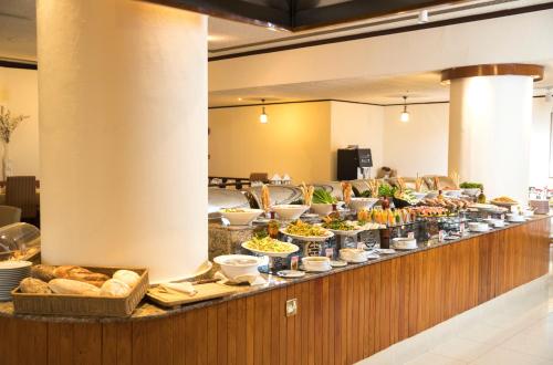 a buffet line with various food dishes and bread at Hotel Muscat Holiday in Muscat