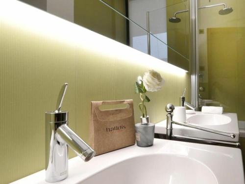 un bagno con lavandino e borsa sul bancone di Castillia, Bosco Verticale Apartment a Milano