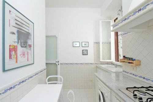 uma cozinha branca com um lavatório e um fogão em Tirso em Roma
