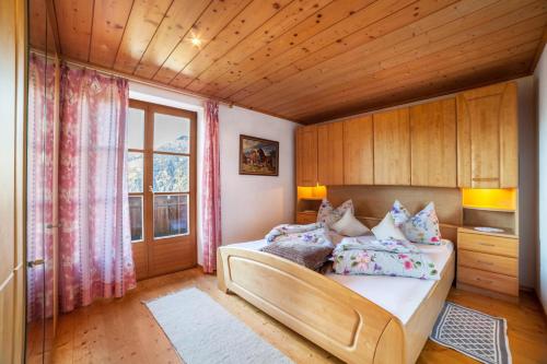 a bedroom with a bed and a large window at Hoferhof Apartement Bergspitze in Schenna