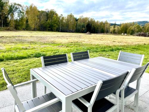 a white picnic table with two chairs and a field at Free Spirit in Nová Pec