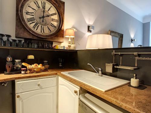 une cuisine avec un évier et une horloge murale dans l'établissement Nestor&Jeeves - MASSENA LOUNGE - Hyper center - By sea, à Nice