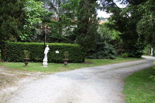 a statue in a garden next to a road at Château du Bois de La Noe in Bouaye