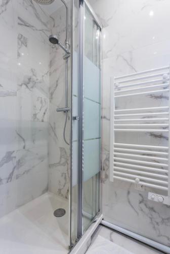 une douche avec une porte vitrée dans une salle de bain dans l'établissement Comfortable apartment - 1BR-4P - Close to Bastille, à Paris