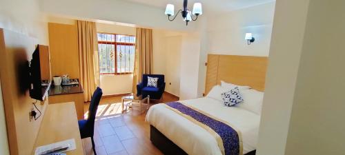 a hotel room with a bed and a desk and a chair at Hays Suites Hotel in Nairobi