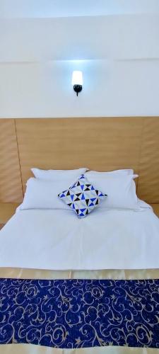 a white bed with two pillows on top of it at Hays Suites Hotel in Nairobi