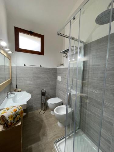 a bathroom with a toilet and a sink and a shower at Villa Ancora in Porto Istana