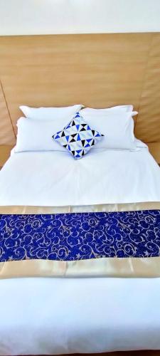 a bed with two blue and white pillows on it at Hays Suites Hotel in Nairobi