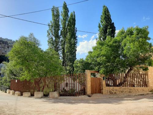 a wooden fence with trees behind it at Casa rural El Molino de Bogarra in Bogarra