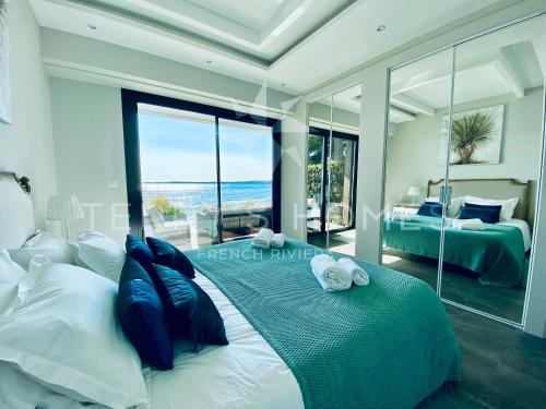 a bedroom with a bed with a view of the ocean at ADRIANA by Terry's Homes WATERFRONT SEAVIEW BEACH in Cannes
