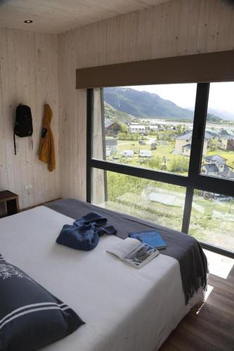 a bed in a room with a large window at Solo Lofts in El Chalten