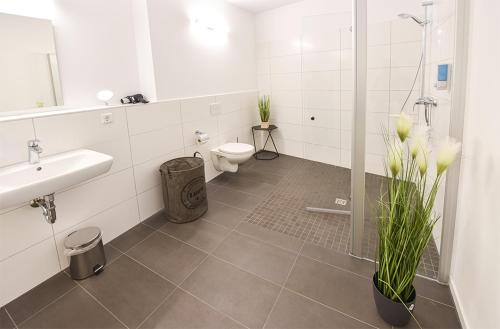 a bathroom with a toilet and a sink and a shower at PRIMA Inn HOTEL & HOF NEURUPPIN - digitales & rezeptionsloses Motel in Neuruppin