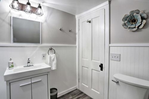 a white bathroom with a sink and a mirror at Updated Home half Mile to Downtown Willoughby! in Willoughby