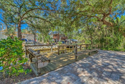 a wooden boardwalk with benches and trees in a park at Private Dock Canal-Front Homosassa Home! in Homosassa