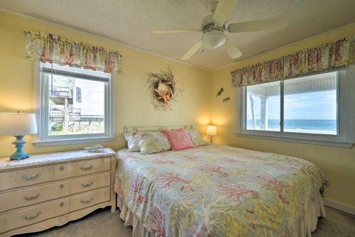 a bedroom with a bed and a dresser and two windows at Peaceful Cottage By The Sea Oceanfront Home! in Surf City