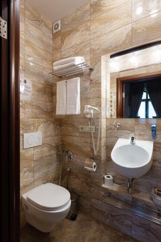 a bathroom with a toilet and a sink at Chopin Hotel in Lviv