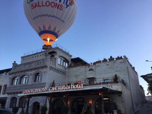 un globo de aire caliente volando delante de un edificio en Underground Cave Suites Hotel, en Göreme