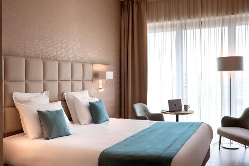 um quarto de hotel com uma cama grande e uma janela em Residhome Luxembourg Esch-Belval em Esch-sur-Alzette