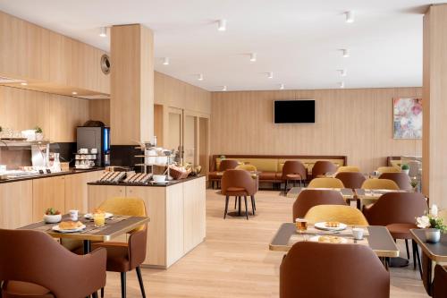ein Restaurant mit Tischen und Stühlen und eine Cafeteria in der Unterkunft Residhome Luxembourg Esch-Belval in Esch-sur-Alzette