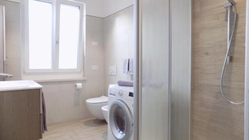 a bathroom with a washing machine and a toilet at MillyHolidays - Apartment Lillà - Center - Nearby Beach - Private Garden - Spa Pool in Bardolino