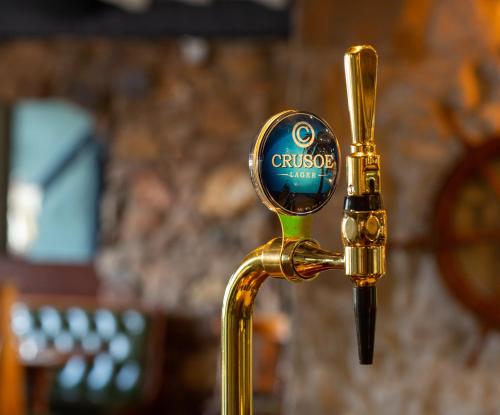 a gold faucet with a magnifying glass on it at The Crusoe in Leven