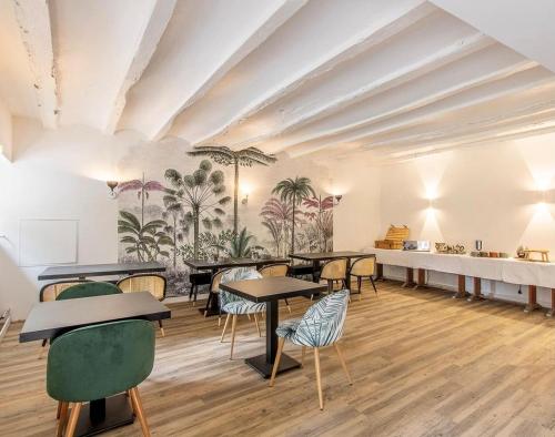 ein Zimmer mit Tischen und Stühlen und eine Wand mit Palmen in der Unterkunft Le Domaine de Moroges in Moroges