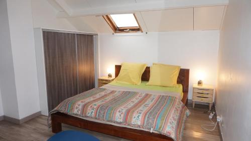 sypialnia z łóżkiem z żółtymi poduszkami w obiekcie Orissa w mieście Saint-Denis