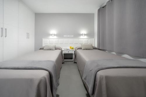 a room with two beds and a stove at Apartamentos Los Papagayos in San Agustin