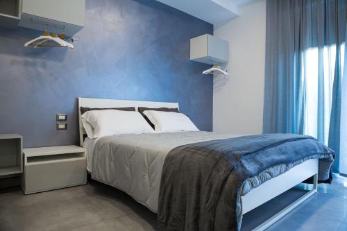 1 dormitorio con cama y pared azul en B&B Amica geniale, en Nápoles