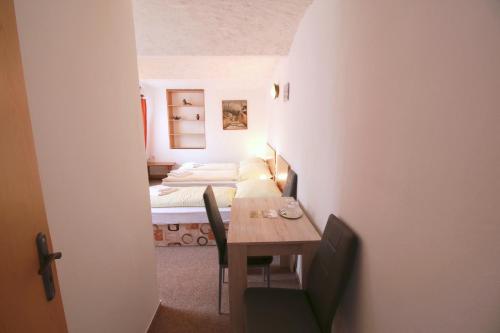 a small room with a table and a bed at Penzion Paseky U Zapadlych vlastencu in Paseky nad Jizerou