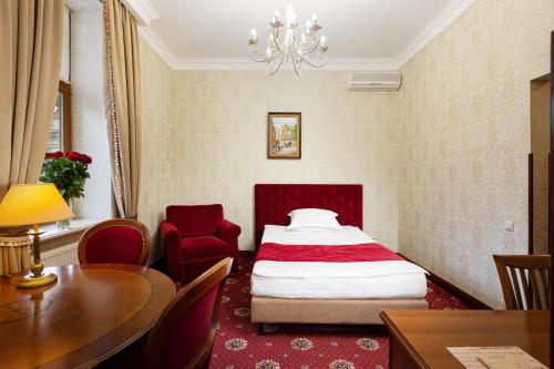 a bedroom with a bed and a table and chairs at Chopin Hotel in Lviv