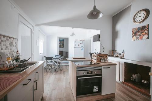 a kitchen with a sink and a stove top oven at Casinha do Roxo in Ervidel