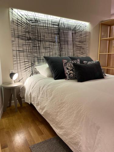 - une chambre avec un lit blanc et des oreillers noirs dans l'établissement Maison Terrasse Beauduc, Arles, à Arles