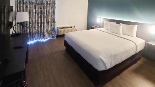 a bedroom with a large white bed and a window at Studio 6 Suites Lawndale, CA South Bay in Lawndale